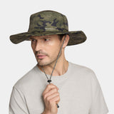 A man wearing a Mission brand camouflage boonie hat with a chin strap, paired with a light gray t-shirt, against a solid light gray background.
