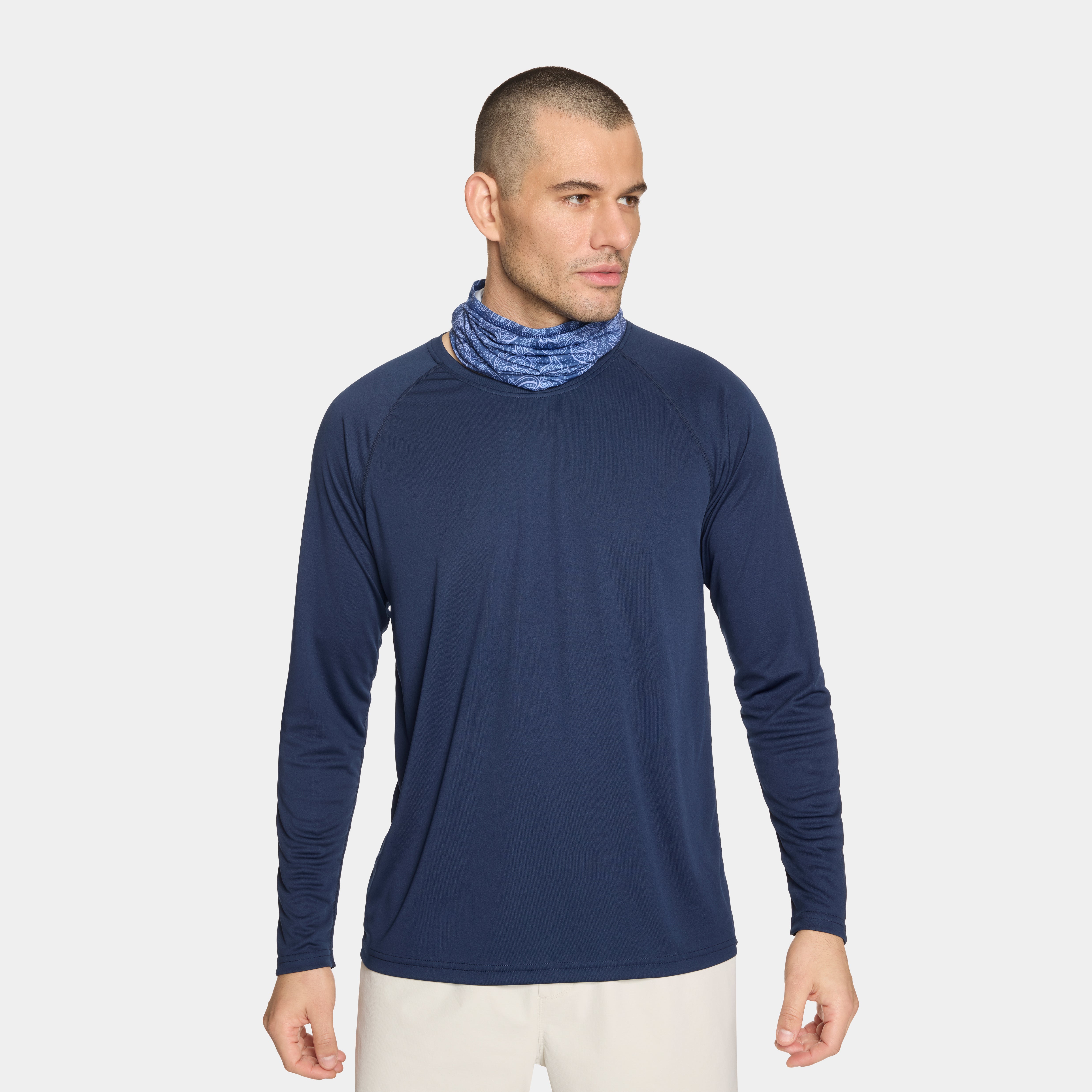 Blue paisley patterned Cooling Neck Gaiter with a Mission logo on a male model with a white background