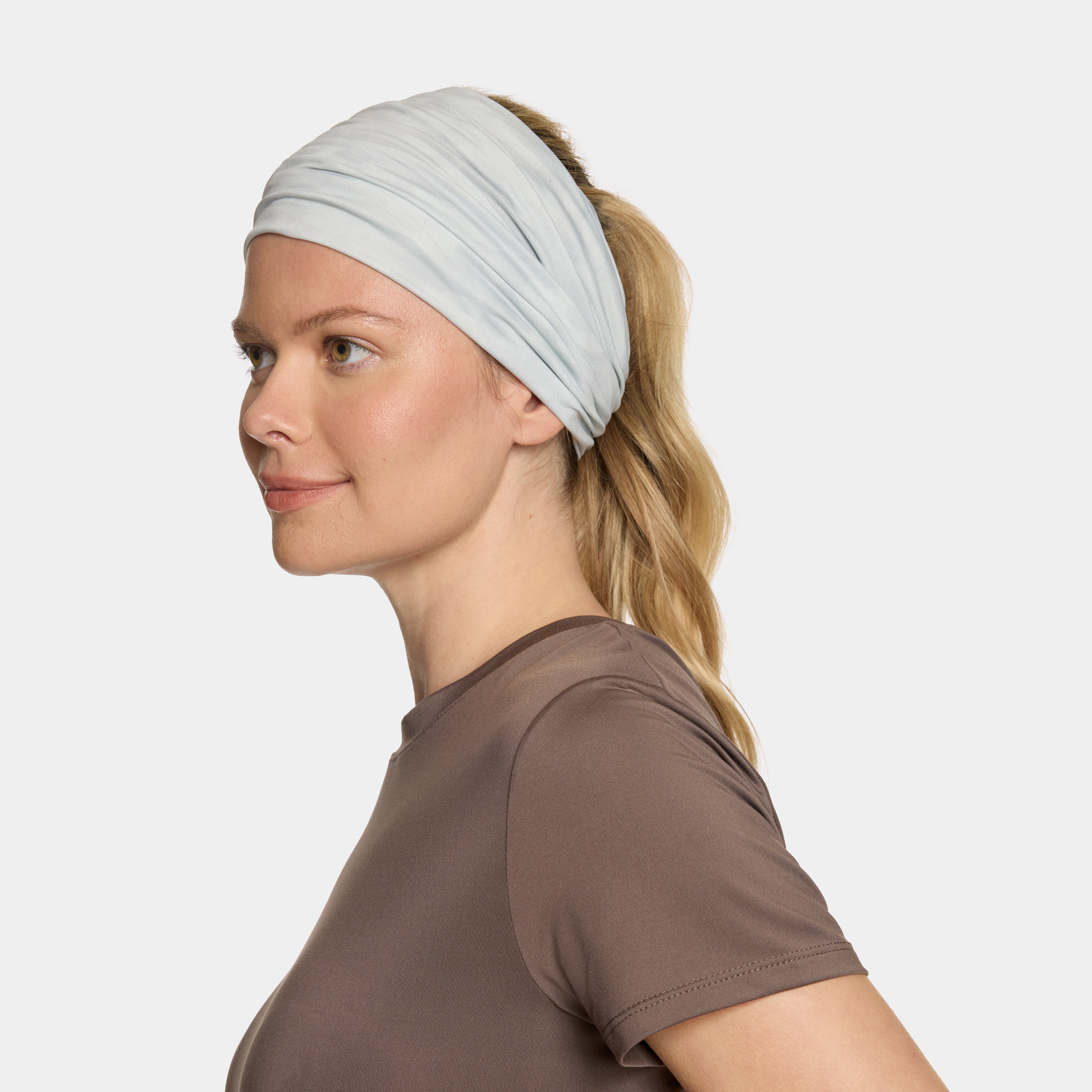 White Camo neck gaiter with a Mission logo on a female model with a white background