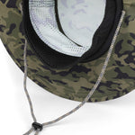 Close-up of the underside of a camouflage boonie hat with a black mesh ventilation panel, black trim, and a silver-and-black adjustable chin strap on a white background.