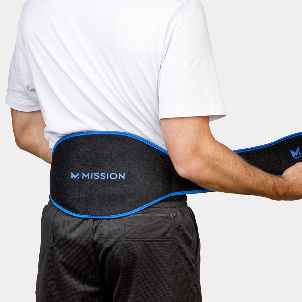 Person wearing a black waist support belt with blue trim on a white background, featuring the 'Mission' brand.