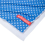 Blue towel with white star pattern and red 'Mission' label on a white background
