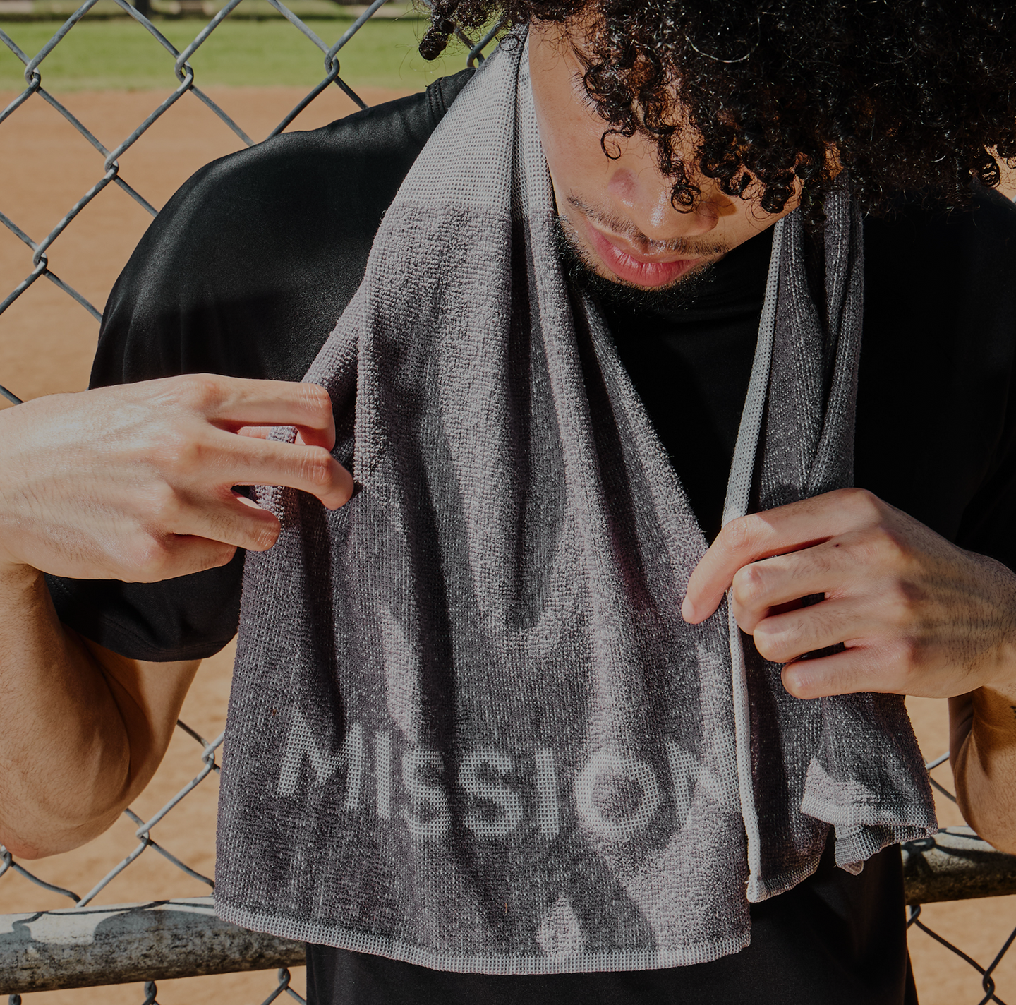 Mission Sideline Towel on model in front of a baseball field