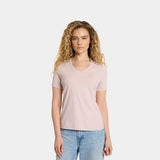 Woman wearing a light pink t-shirt and blue jeans on a white background