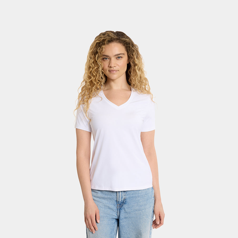Woman wearing a plain white t-shirt and light blue jeans on a white background