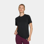 Woman wearing a black athletic shirt and purple leggings on a white background