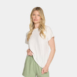 Woman wearing a white t-shirt and green pants on a light gray background